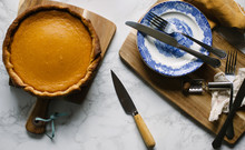 Freshly Baked Pumpkin Pie On A Table With Kitchen Utensils.