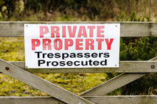 Sign On A Wooden Gate Advising Public That This Is Private Property And Trespassers Will Be Prosecuted