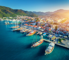 Aerial View Of Boats And Beautiful Architecture At Sunset In Marmaris, Turkey. Colorful Landscape With Boats In Marina Bay, Sea, City, Mountains. Top View From Drone Of Harbor With Yacht And Sailboat