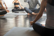 © fizkes - Young sporty people practicing yoga lesson with instructor, sitting, making Alternate Nostril Breathing, nadi shodhana pranayama exercise, working out, close up image. Wellbeing and wellness concept