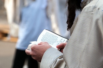 Wall Mural - Prayer. The Jewish Hasid reads a religious book. Close-up of a book and hands.