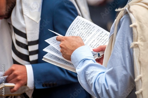 Zdjęcie XXL Modlitwa. Żydowski chasid czyta książkę religijną. Zakończenie książka i ręki.