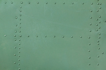 Old painted metal background detail of a military aircraft, surface corrosion.