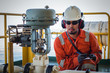 © xmentoys - Operator or worker recording operation data of oil and gas process at production plant, Offshore oil and gas industry in the sea or gulf, Operator monitor production process and routine daily record.