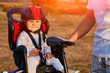 © Aleksey - Little girl in red and black helmet seat bicycle in city park