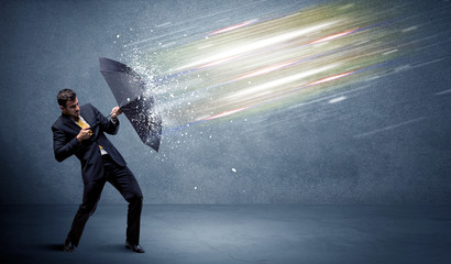 Wall Mural - Business man defending light beams with umbrella concept