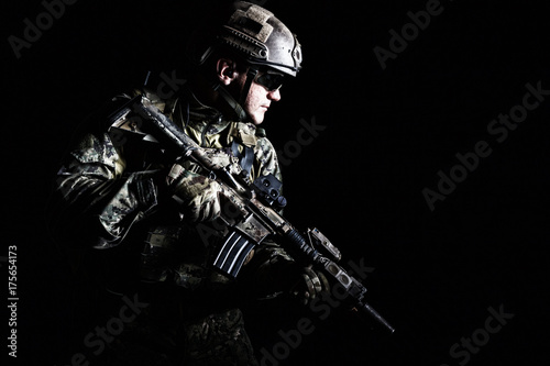Zdjęcie XXL Przyrodniej długości niskiego kąta studia strzał sił specjalnych żołnierz w śródpolnych mundurach z broniami, portret na czarnym tle. Okulary ochronne są włączone