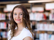 © Sergey Nivens - Happy female student holding books at the library
