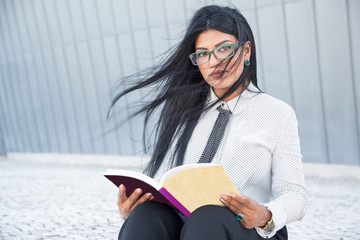 Confident smart woman reading business book