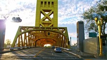 Smooth Cinematic Shot Of Driving Through Vertical Lift Tower Bridge Across The Sacramento River In Sacramento Downtown, Capital Of California State On A Warm, Sunny Summer Day