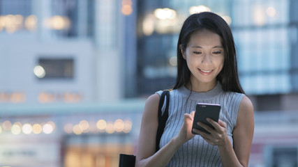 Canvas Print - Young woman using mobile phone at night