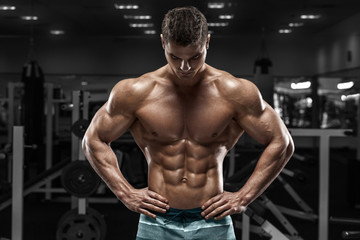  Sexy muskularny mężczyzna w siłowni, w kształcie brzucha. Silny męski nagi tors, ćwiczenia