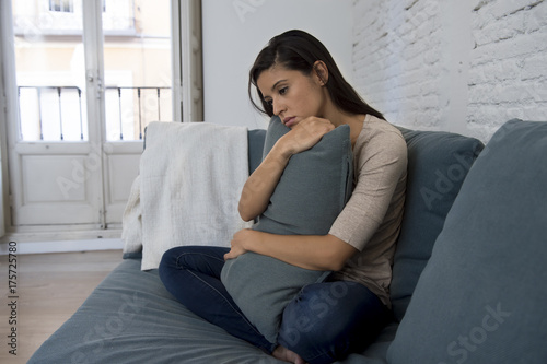 Zdjęcie XXL młoda atrakcyjna kobieta latin leżącego w domu kanapie zmartwiony cierpienia depresji czuje się smutny i zrozpaczony