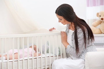 Wall Mural - Mother lulling baby in crib at home