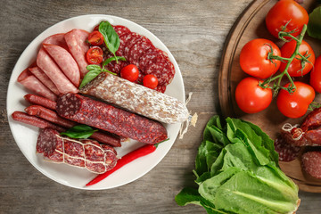 Poster - Plate with delicious sliced sausages on wooden table