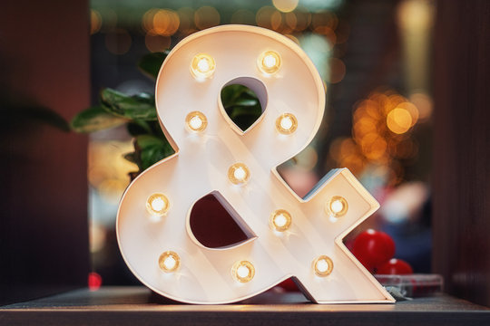 A huge illuminated ampersand on the table
