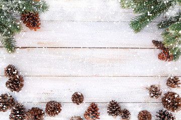 christmas background - fir tree and pine cones decorating rustic elements on white wood table with s