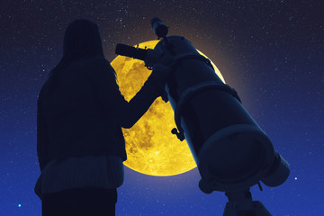 Wall Mural - girl looking at the stars and full moon through a telescope.