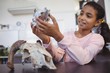Happy elementary student examining animal skull by desk