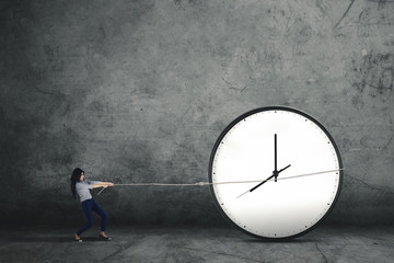 Woman pulling a big clock