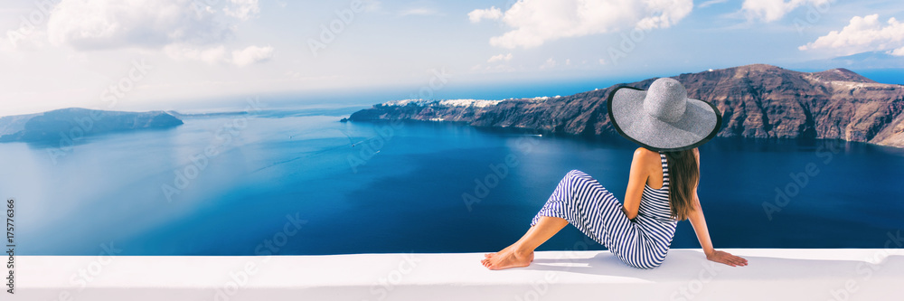 Travel luxury cruise vacation holiday woman panoramic banner. Sun hat maxi dress woman relaxing at sea view in Santorini, Oia, Greece. Europe destination. - obrazy, fototapety, plakaty 