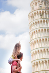 Family of father and little kid background the Learning Tower in Pisa. Pisa - travel to famous places in Europe.