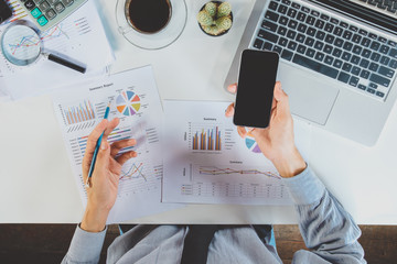 Businessman analyzing financial data on smartphone