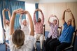 © WavebreakMediaMicro - Female doctor stretching with seniors sitting on chairs