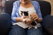 © WavebreakMediaMicro - Midsection of senior woman stroking kitten while sitting on