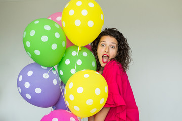 Beautiful cute cheerful girl with colored balloons. Holiday Happy Birthday