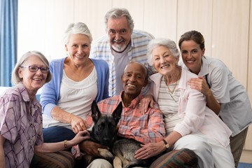 Wall Mural - Portrait of smiling doctor and senior friends with dog