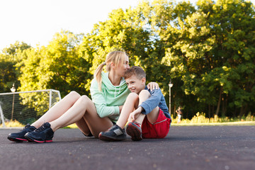 The son with his mom outdoors. Mother and her child having fun together. Little kid express the love to his young mommy.