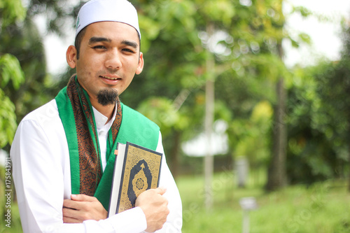 Zdjęcie XXL Muzułmański mężczyzna trzyma al-Quran w zbliżenie strzale.