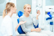© Vadym Huzhva - A woman is sitting at a dentist's reception. She looks in the mirror at her teeth. Woman smiling