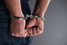 Man With His Hands Handcuffed In Criminal Concept