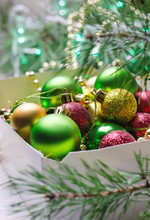 Box With Red, Golden And Green Christmas Balls. Christmas Background