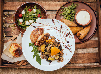 Wall Mural - Tasty meat rolls with sour cream and salad on wooden table