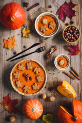 Wall Mural - Homemade Pumpkin pie for Thanksgiving dinner on wooden table with holiday decorations. Table top view. Autumn food, Thanksgiving day food