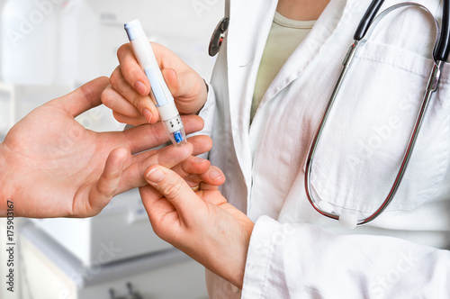 Cuadros en Lienzo Measuring blood sugar on finger - diabetes concept