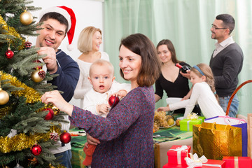 Happy family with Christmas tree at home.