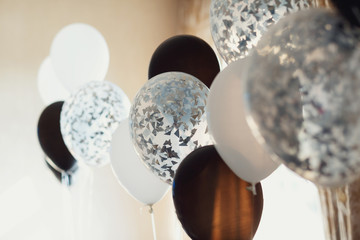 Wall Mural - White and black balloons hang in the room