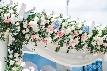 Poster - rich flower garland made of white roses and blue hydrangeas hangs on the white ladder