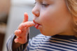funny baby toddler blonde boy licks a finger