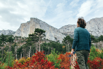 Canvas Print - Man traveling in autumn forest by the mountain