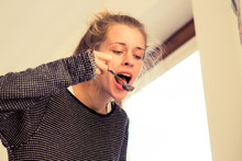 Young Woman With A Spoon Eating Cereals