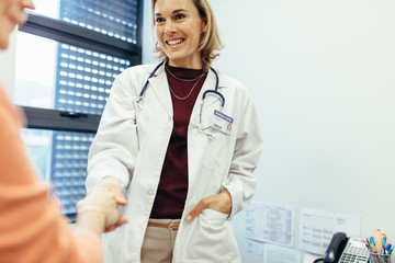 Female physician shaking hands with her patient