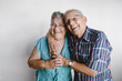 © Rob and Julia Campbell/Stocksy - Happy senior couple looking at camera on white background