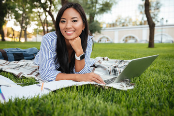 Sticker - Close-up portrait of cheerful asian student, looking at camera, while using laptop, outdoor