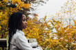© Gabriel (Gabi) Bucataru/Stocksy - Black girl looking out a scenic view in a fall colored forest