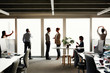 © Aila Images/Stocksy - Profile silhouette of business team close to windows mulittasking